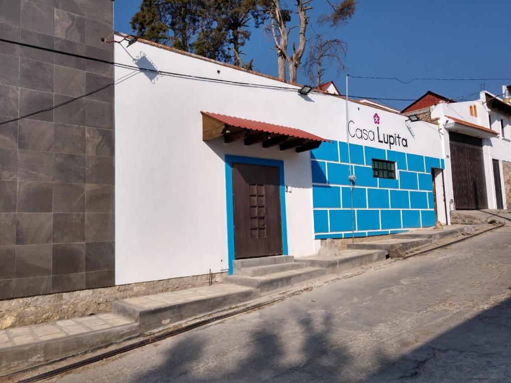 un bâtiment bleu et blanc sur le côté d'une rue dans l'établissement CASA LUPITA, à Mineral del Monte