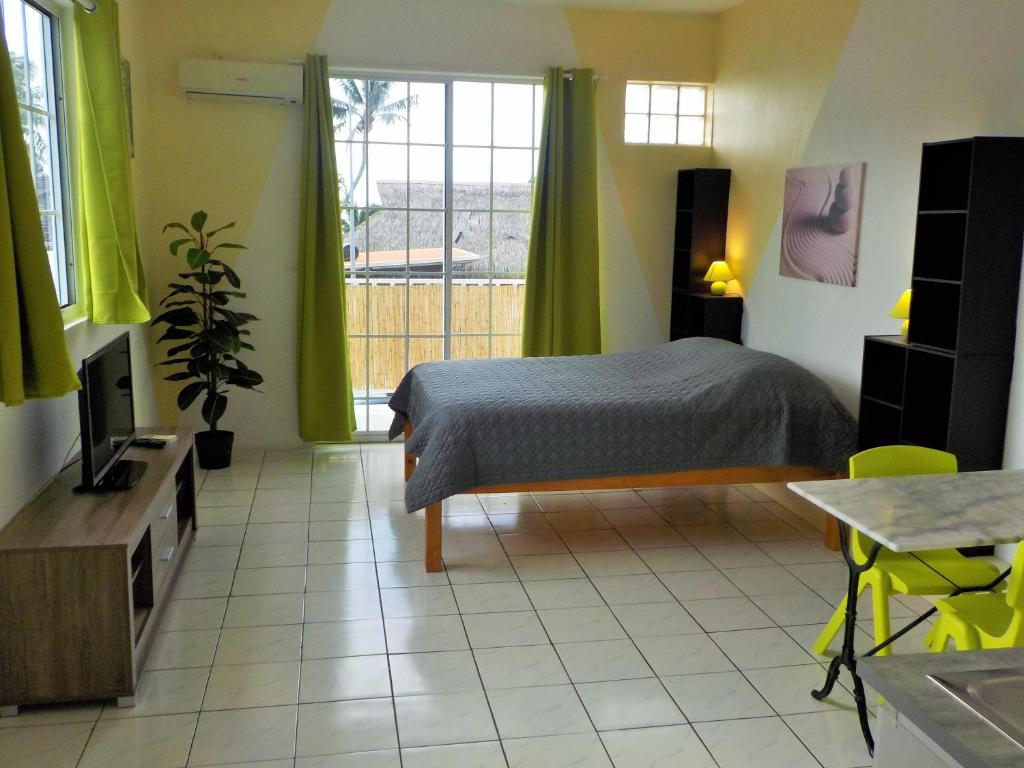a bedroom with a bed and a tv and a window at Apartment Studio Halfon in Moorea