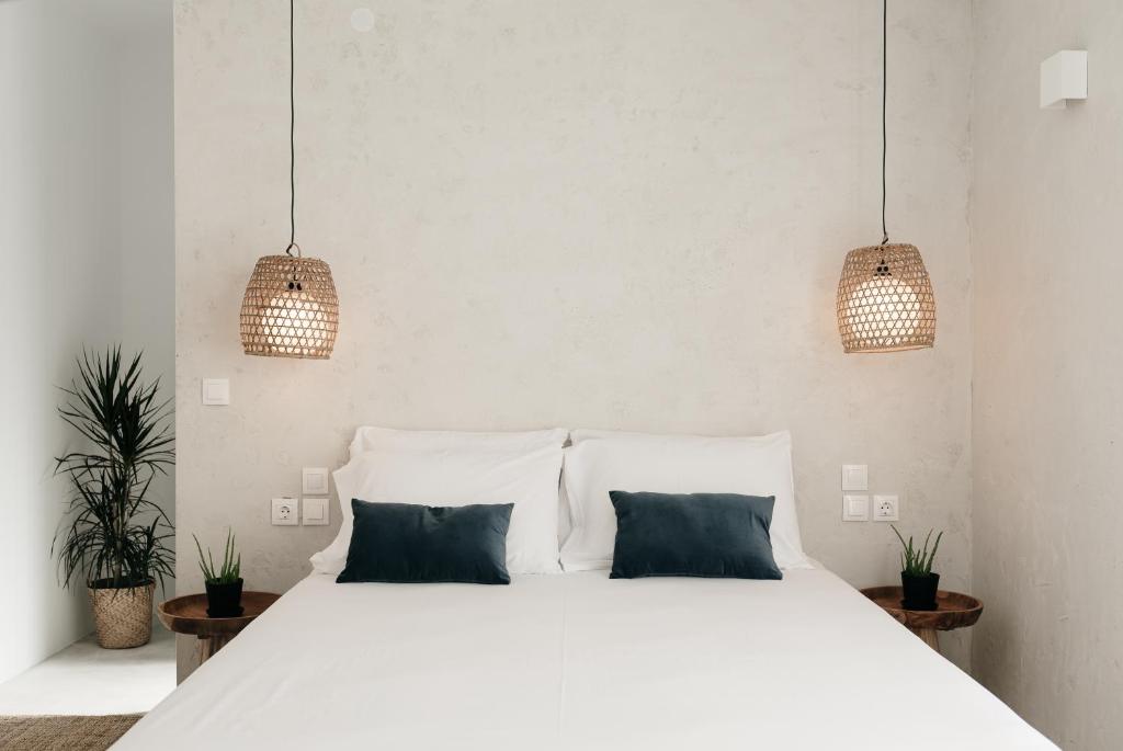 レフカダにあるBohèmian Boutique Hotel Lefkadaのベッドルーム1室(白いベッド1台、青い枕2つ付)