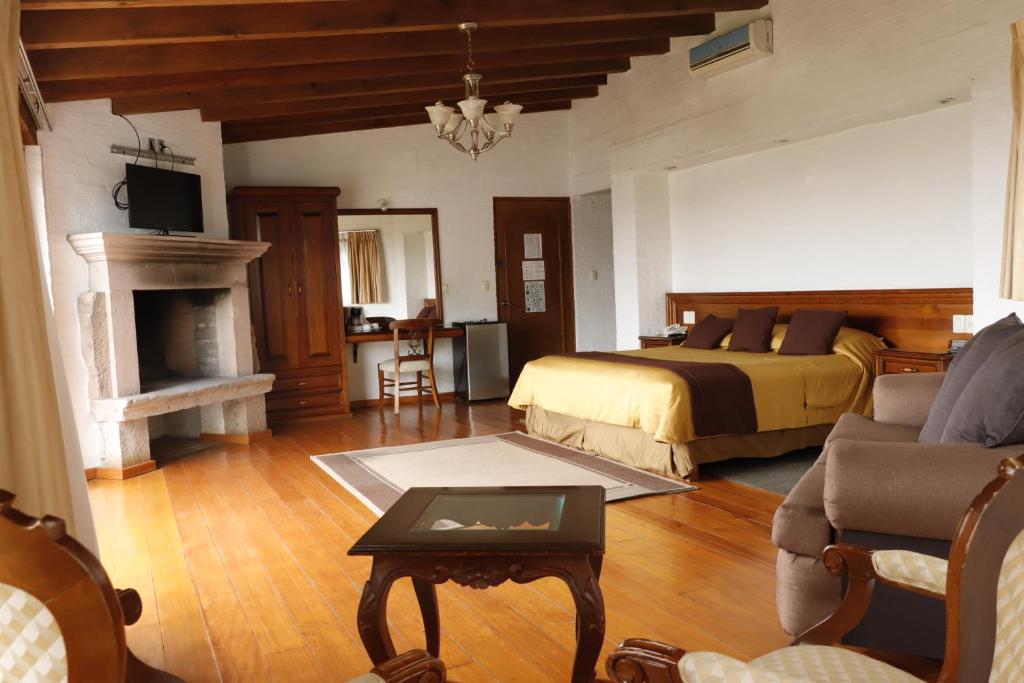 a bedroom with a bed and a living room with a fireplace at Casa de la Loma in Morelia