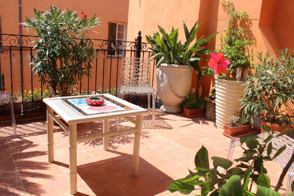 グラースにあるDuplex spacieux avec terrasse - Centre Historique de Grasseの鉢植えの植物と白いテーブルが備わるパティオ