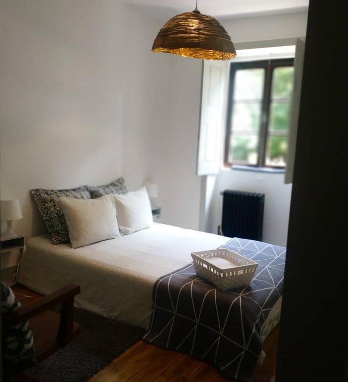 um quarto com uma cama com um cesto em Quinta da Regadas em Arouca