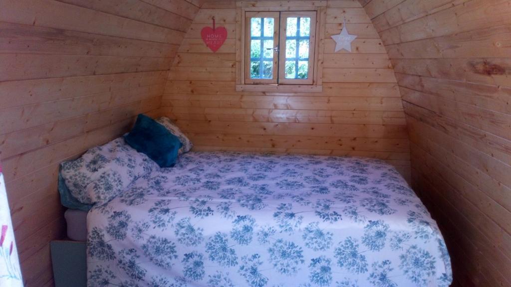 um quarto com uma cama num chalé de madeira em Carnamuff Glamping em Ballykelly