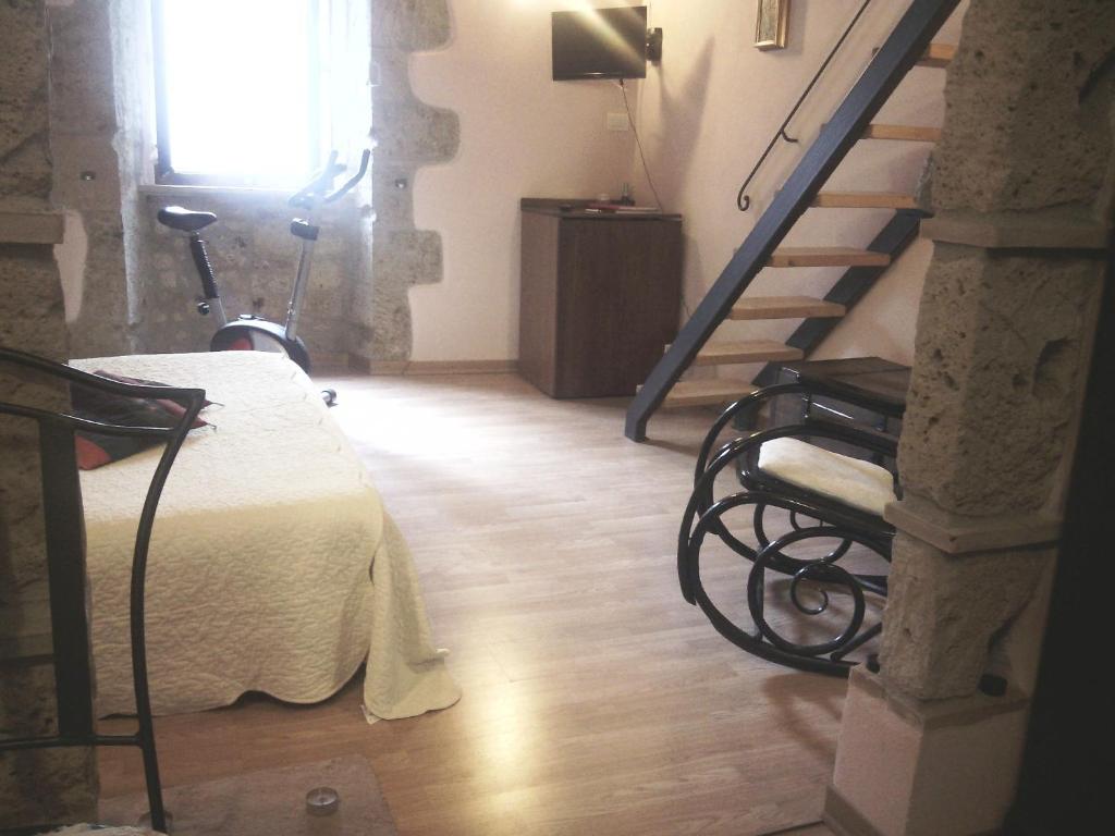 a bedroom with a bed and stairs in a room at 4 Assi in Pitigliano
