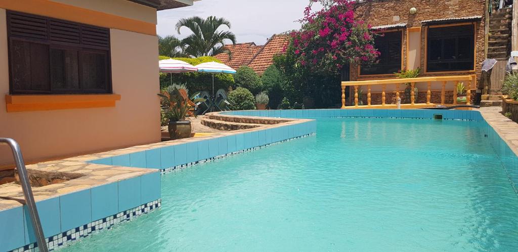 a swimming pool next to a house at Keelan ace villas in Kampala