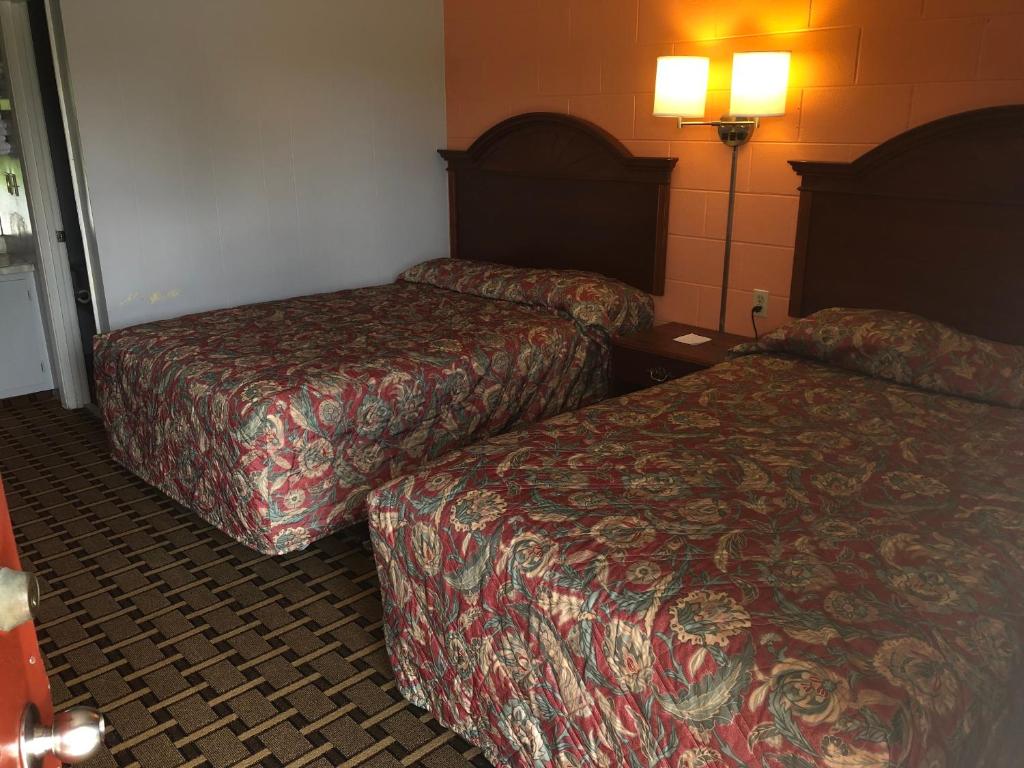 Economy Inn في كروسفيل: غرفه فندقيه سريرين ومصباحين