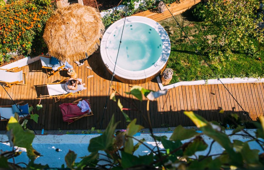 an overhead view of a swimming pool with a man sitting in a chair next to at Selina Milfontes in Vila Nova de Milfontes