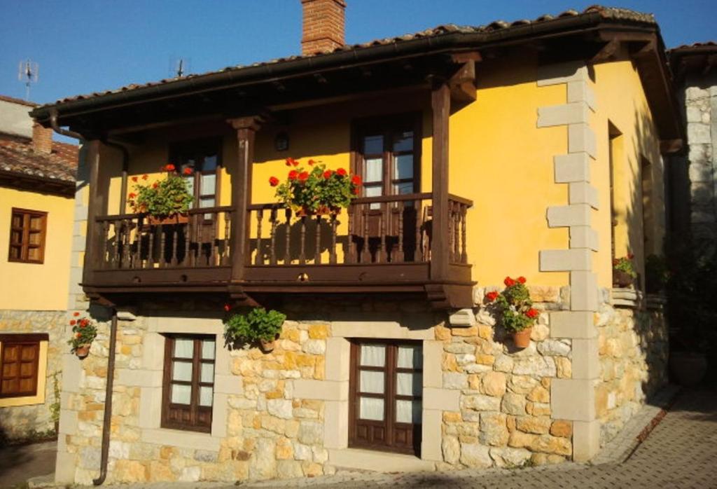 a building with a balcony with flowers on it at La Foina in Ceceda de Abajo