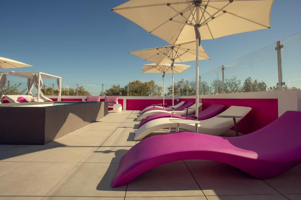 a row of purple chairs and umbrellas on a roof at Chic Studios in Parede