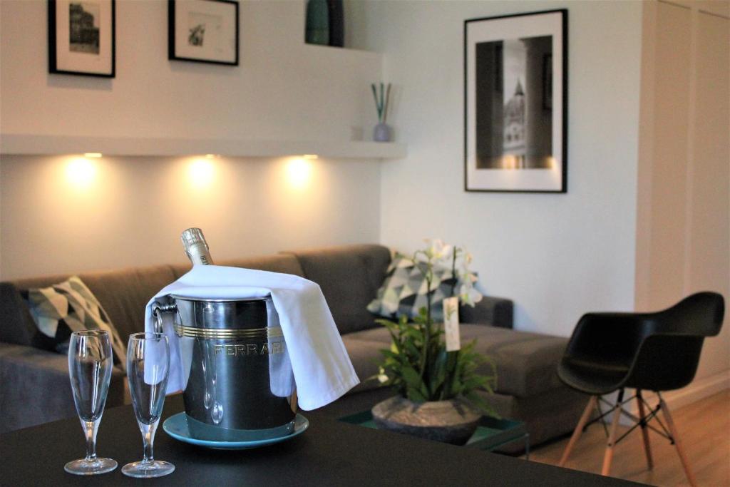uma sala de estar com um sofá e uma mesa com copos de vinho em VATICAN APARTMENT MELORIA em Roma