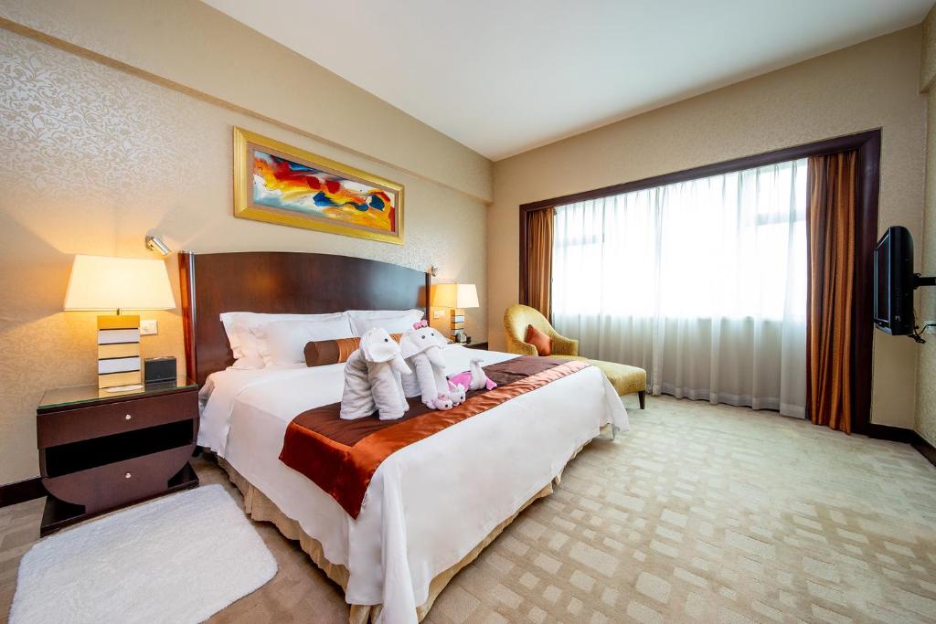 Postel nebo postele na pokoji v ubytování Grand International Hotel