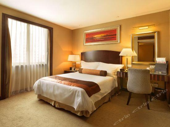 Postel nebo postele na pokoji v ubytování Grand International Hotel
