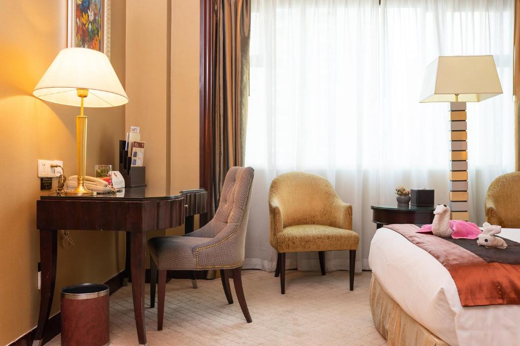 Postel nebo postele na pokoji v ubytování Grand International Hotel