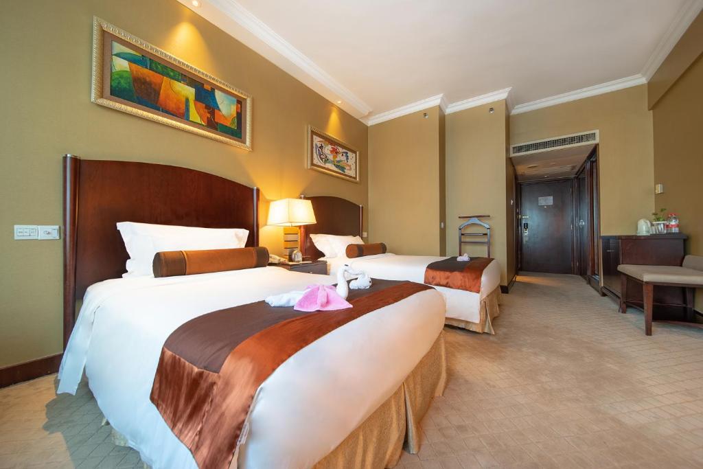 Postel nebo postele na pokoji v ubytování Grand International Hotel