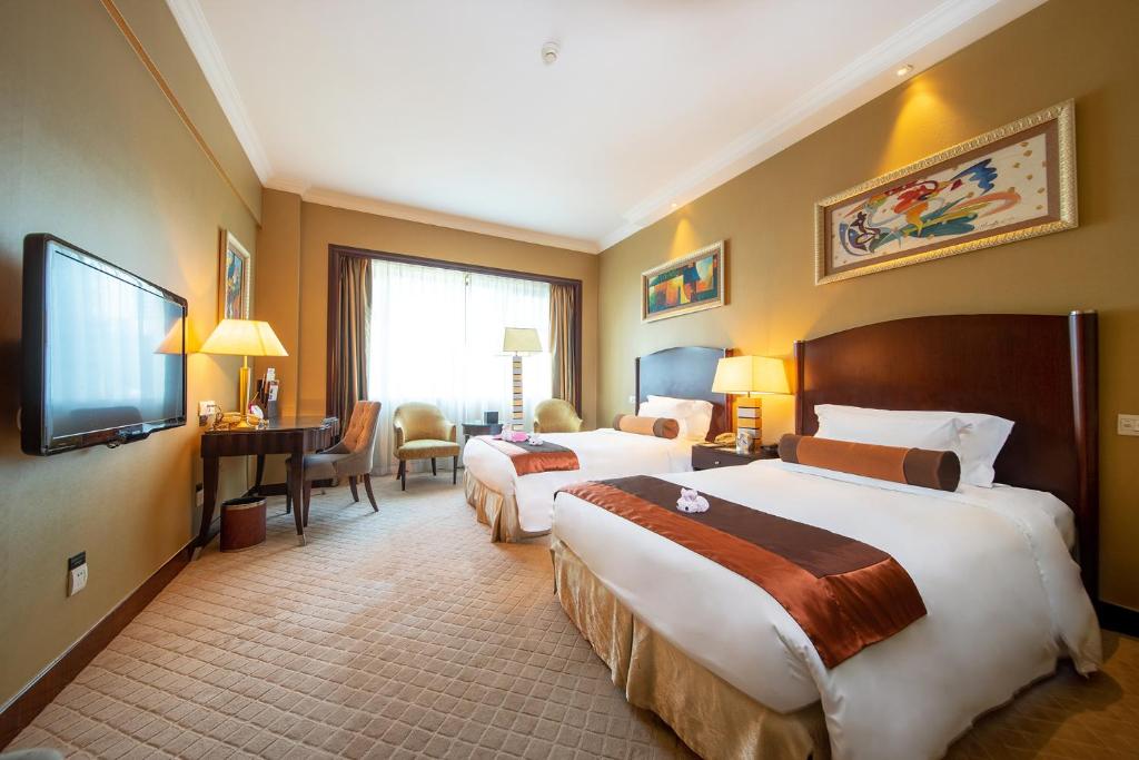 Postel nebo postele na pokoji v ubytování Grand International Hotel