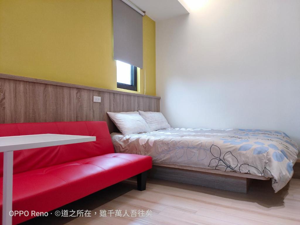 Zimmer mit einem Bett, einem Tisch und einer roten Bank in der Unterkunft 禾心居He Xin Ju Homestay in Jinning