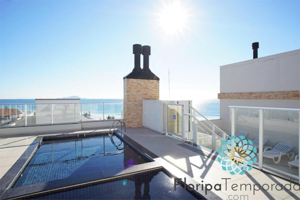 a swimming pool on the roof of a house at Gaivotas Apart - Frente Mar in Florianópolis