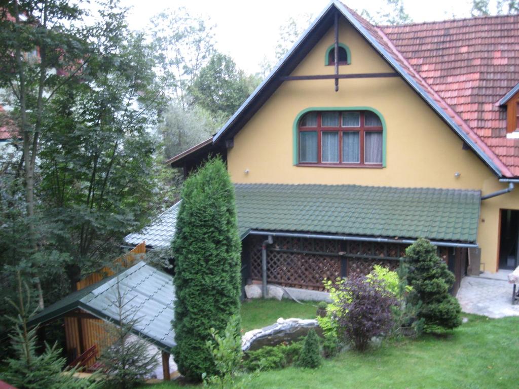 une maison jaune avec un toit rouge dans l'établissement Chalupa Mlyn Dolný Kubín, à Dolný Kubín