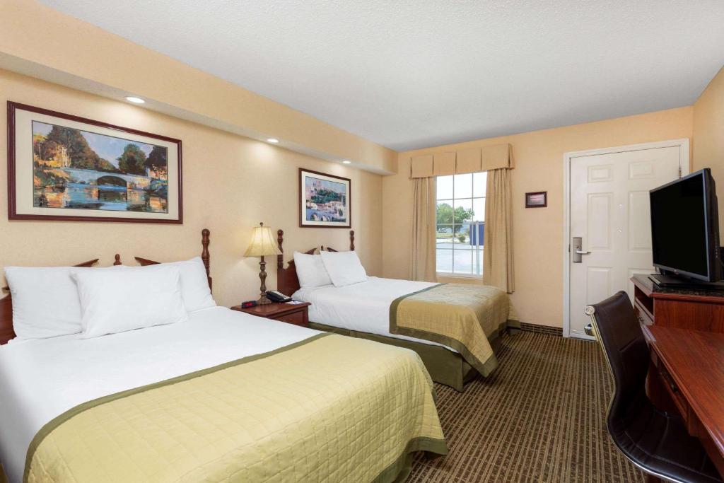 a hotel room with two beds and a flat screen tv at Baymont by Wyndham Easley/Greenville in Easley