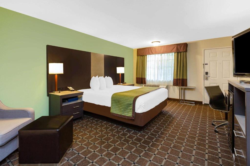 a hotel room with a bed and a television at Travelodge by Wyndham Angels Camp CA in Angels Camp