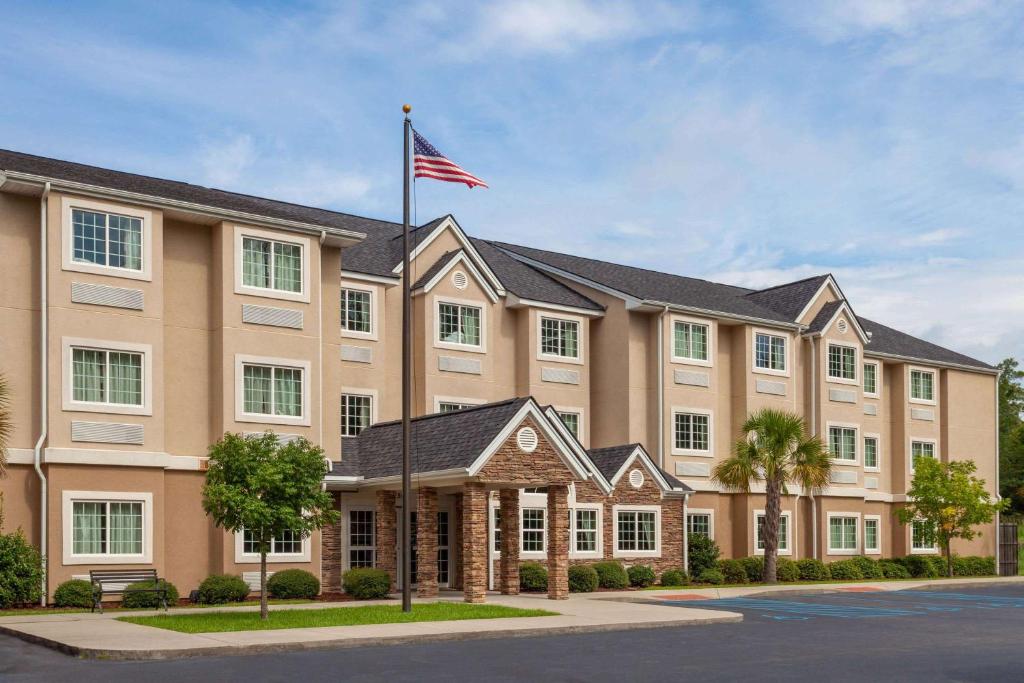 an exterior view of a hotel with an american flag at Microtel Inn & Suites by Wyndham Columbia in Columbia