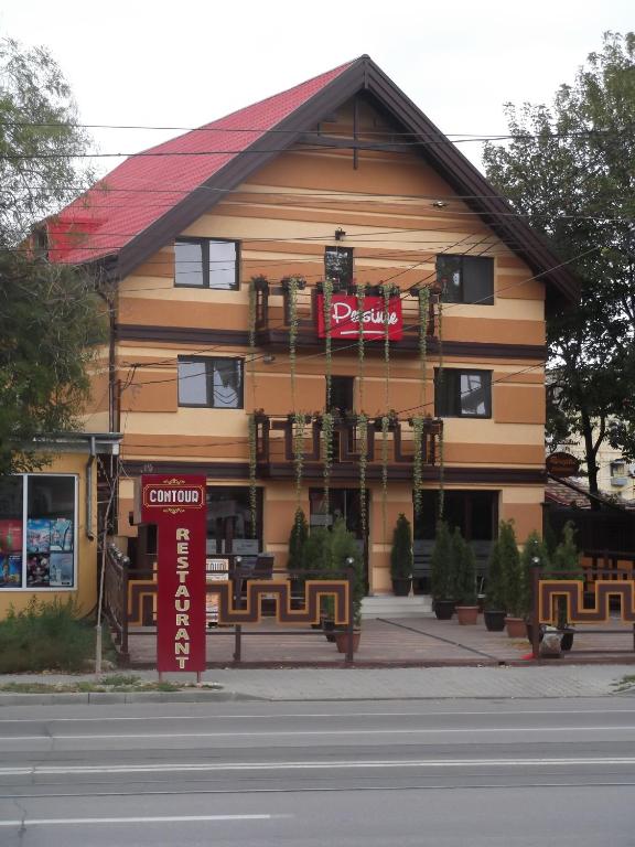 a building with a sign on the front of it at Pensiunea Contour in Iaşi
