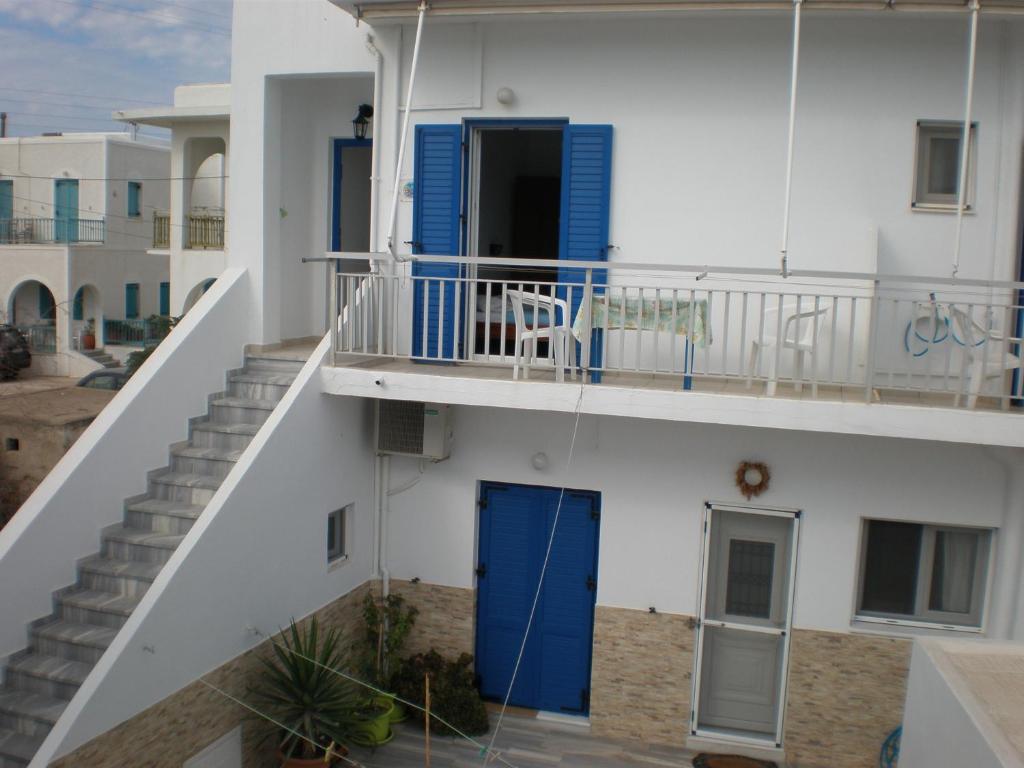 a balcony of a building with a blue door and stairs at Chrysa in Antiparos