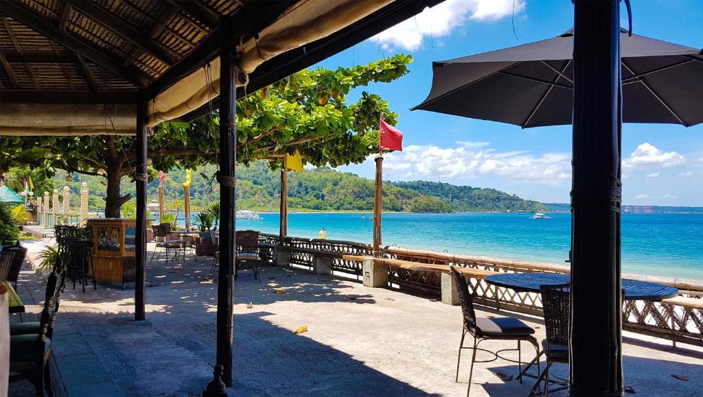 Playa Papagayo Beach Inn في اولونجابو: طاولة مع مظلة على الشاطئ