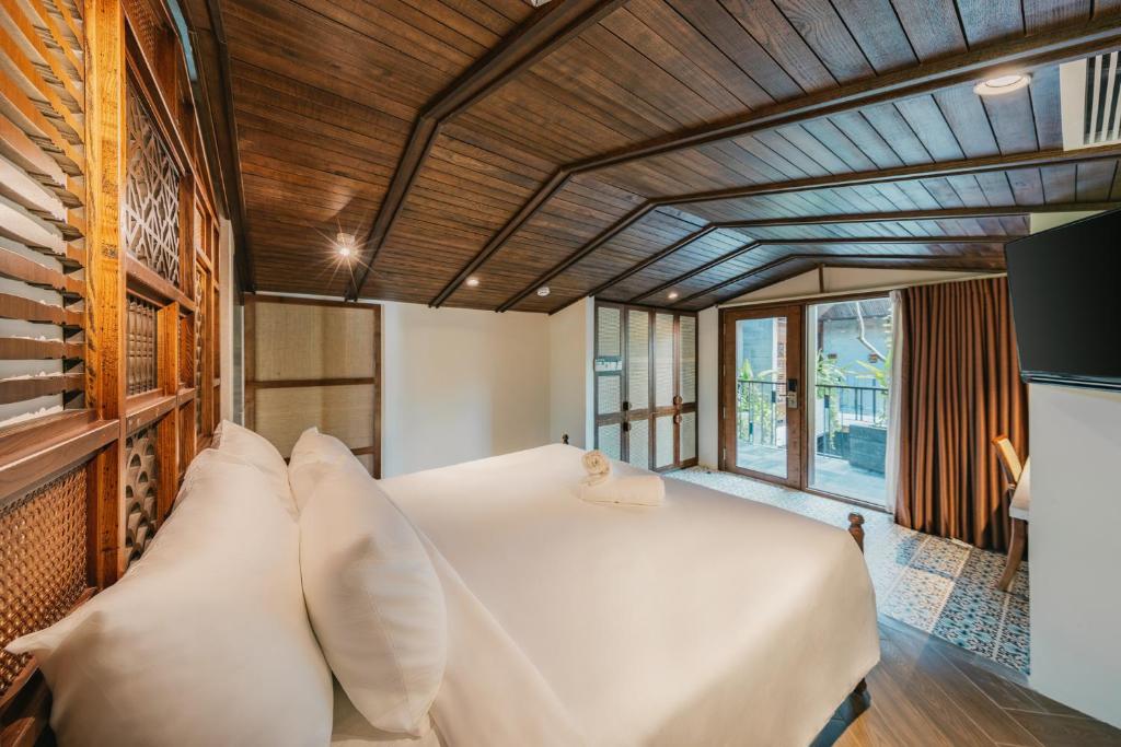 a bedroom with a large white bed with pillows at Minh Boutique in Danang