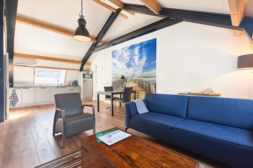 a living room with a blue couch and a table at RIANT APPARTEMENT CENTRUM MIDDELBURG in Middelburg