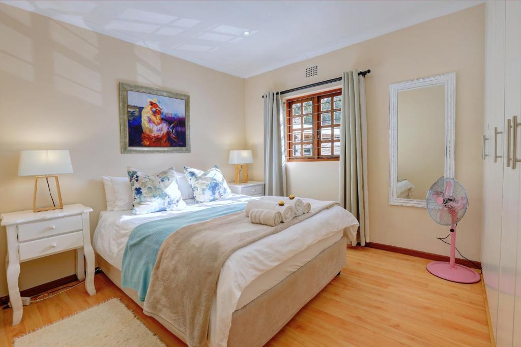 a bedroom with a large bed with a fan on it at No.8 on Wright Street in George