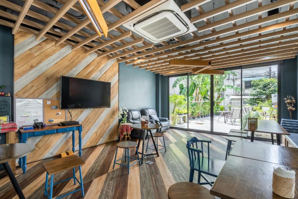 a room with wooden walls and tables and a flat screen tv at W Station in Bangkok