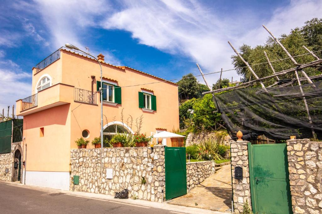 a house with a stone wall and a fence at Casa Rosada in Massa Lubrense