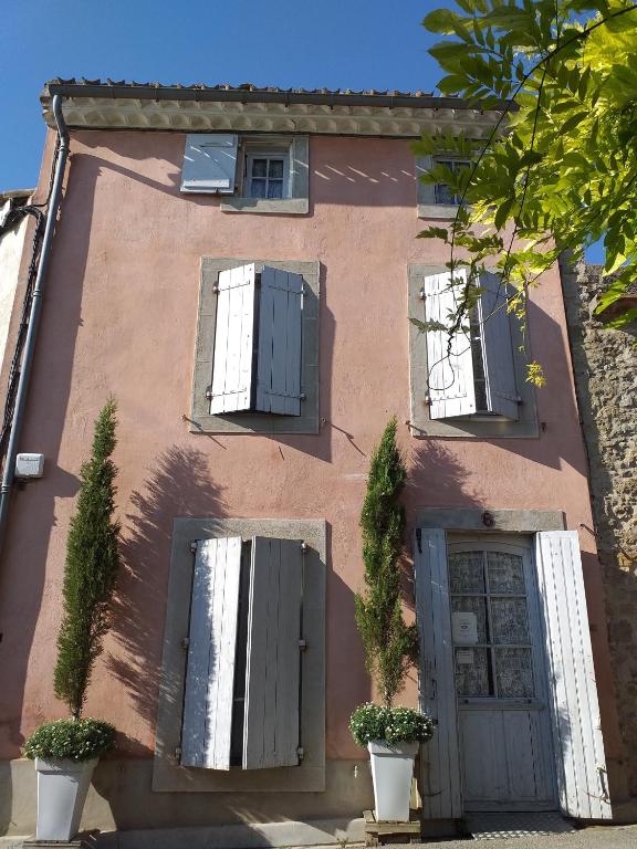 a pink house with two windows and a door at Riverside Home Cottage in Trèbes