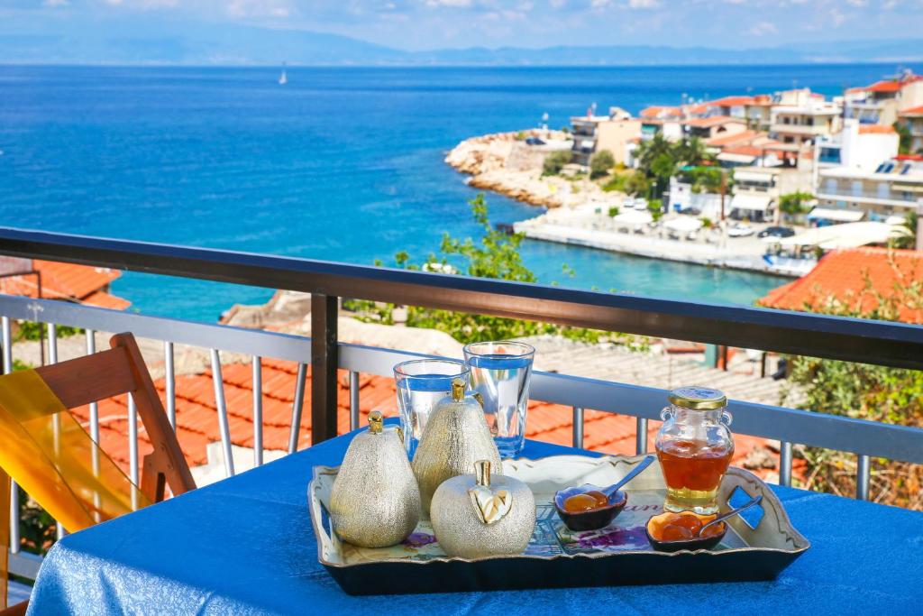 een blauwe tafel met een dienblad met eten op een balkon bij Athanasia Rooms in Mariaí