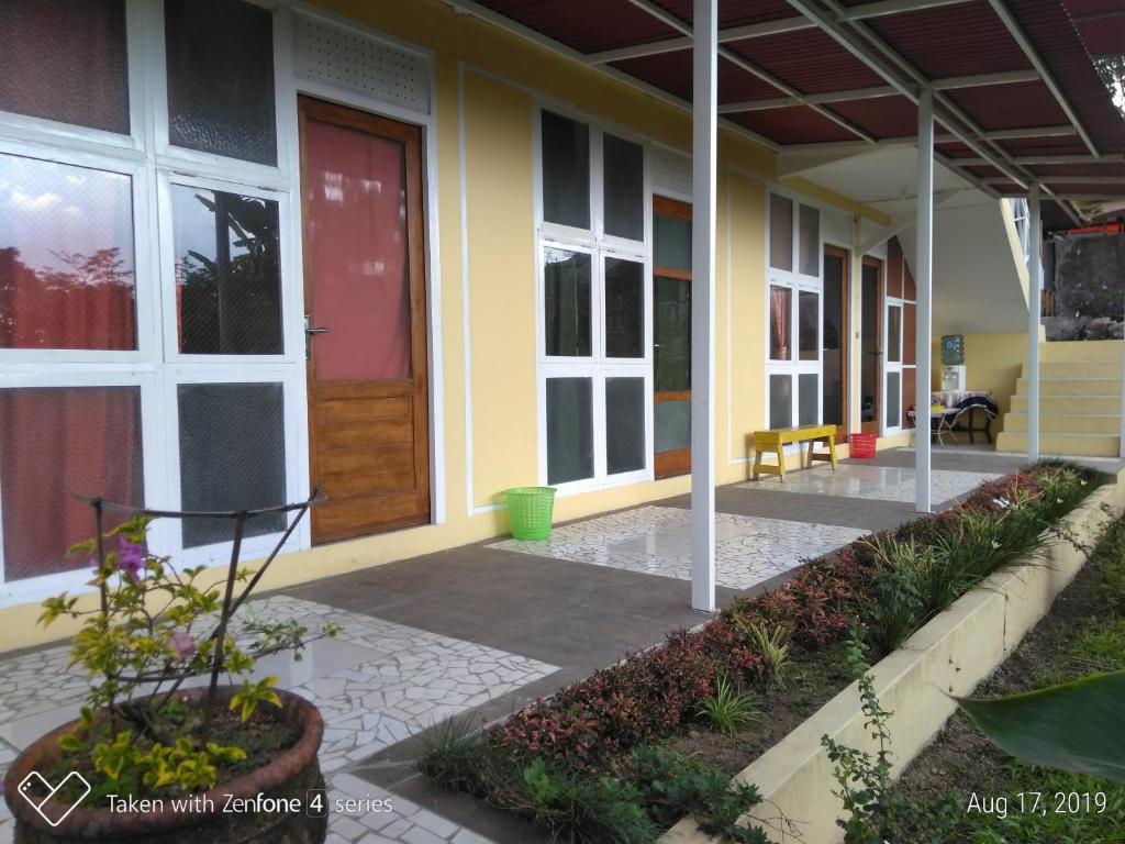 a front porch of a house with a red door at Rumah Sakinah in Wonosobo