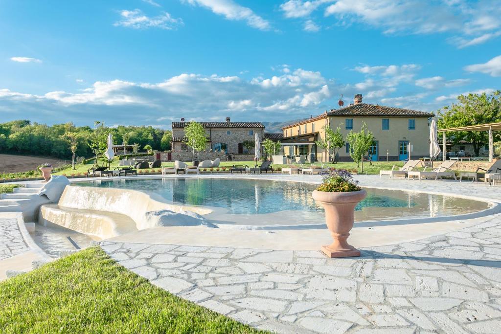 a swimming pool in a yard with a house in the background at Tenuta Le Tre Virtù in Scarperia