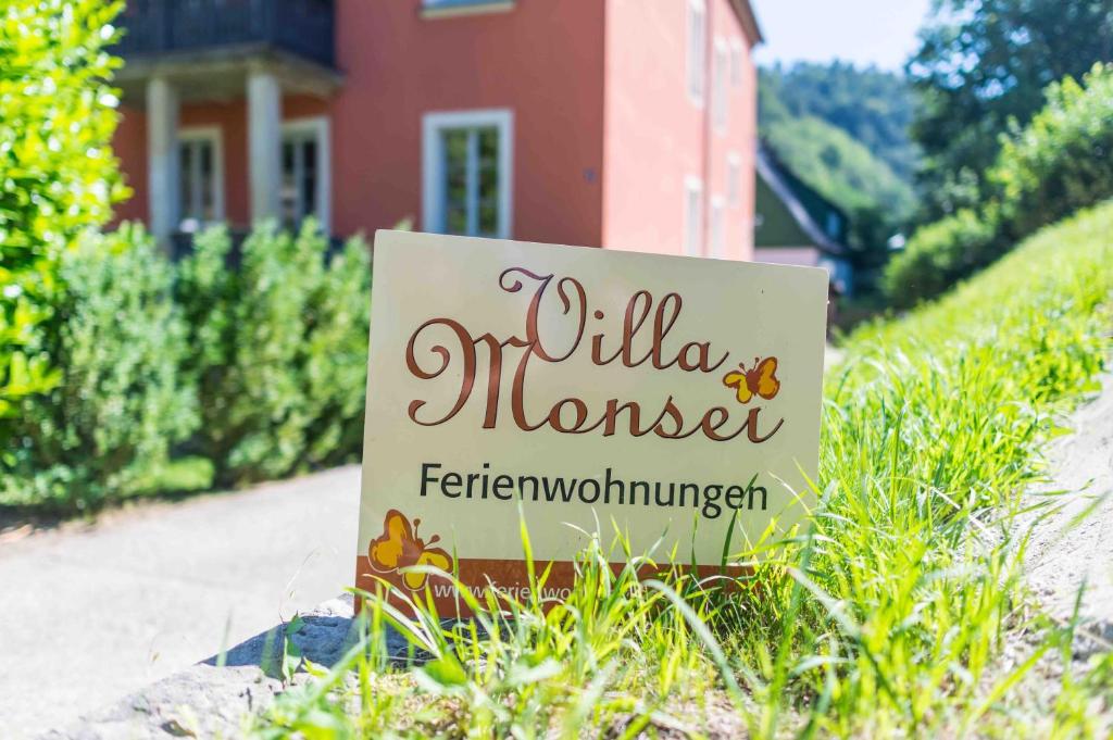 ein Schild im Gras vor einem Haus in der Unterkunft Villa Monsei in Bad Schandau