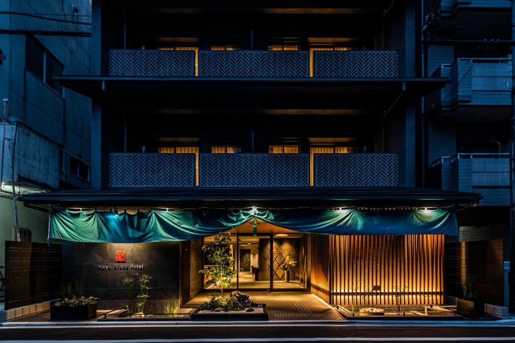 une façade de bâtiment avec un auvent vert dans l'établissement RESI STAY Mayu Grace Hotel, à Kyoto
