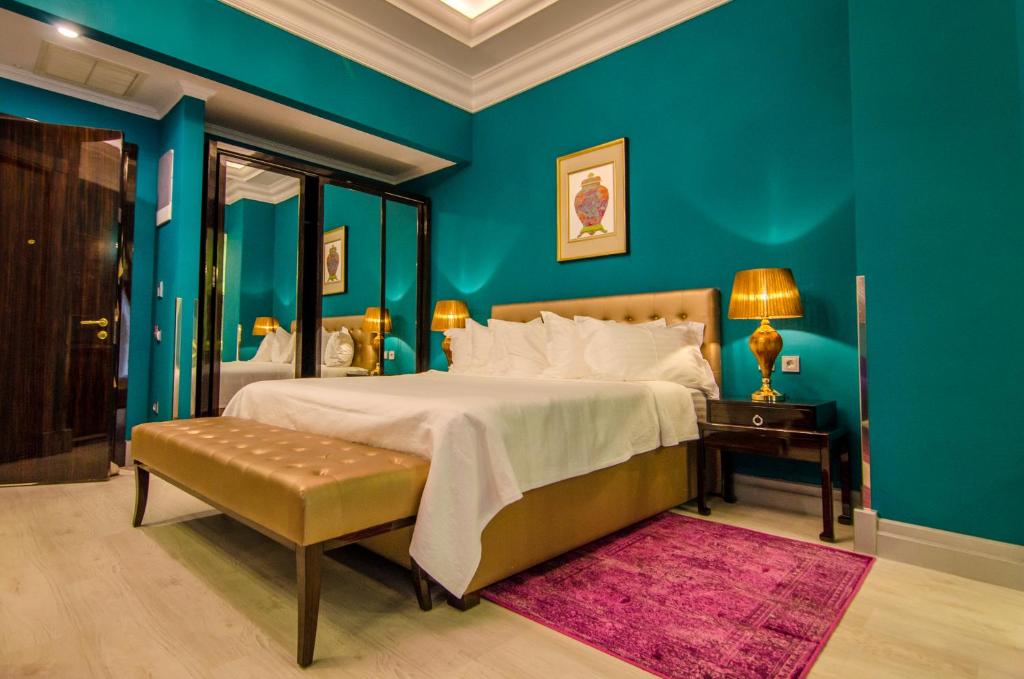 a bedroom with a large bed and blue walls at Phoenicia Boutique Hotel - Adults Only in Mamaia Sat/Năvodari