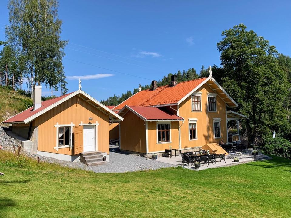 a small yellow house with a patio and grass at Vrangfoss Sluse in Nes