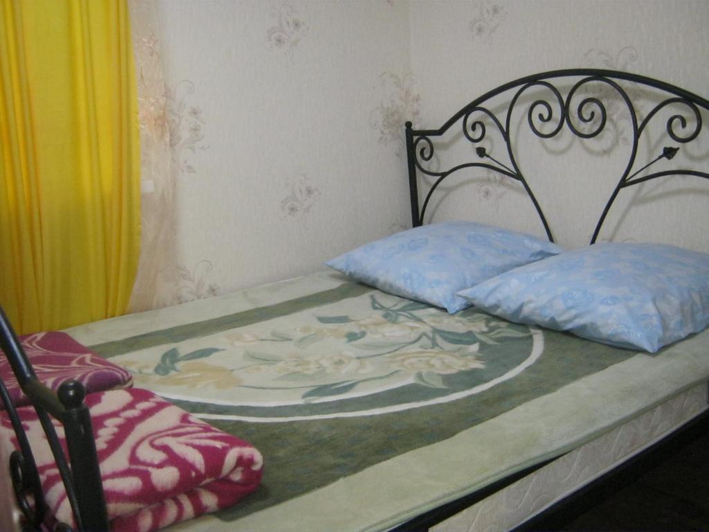 a bed with two pillows on top of it at Apartment in Pyatigorsk in Pyatigorsk