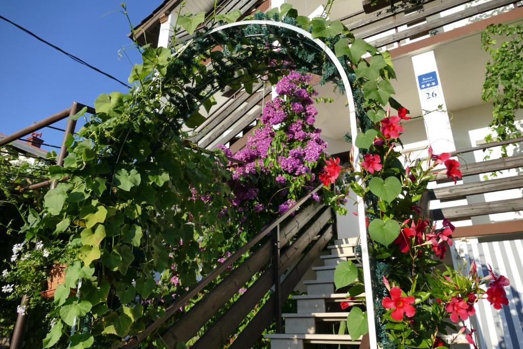 an archway with flowers on the stairs of a house at City Retro Chic Apartment Magdalena Trogir in Trogir