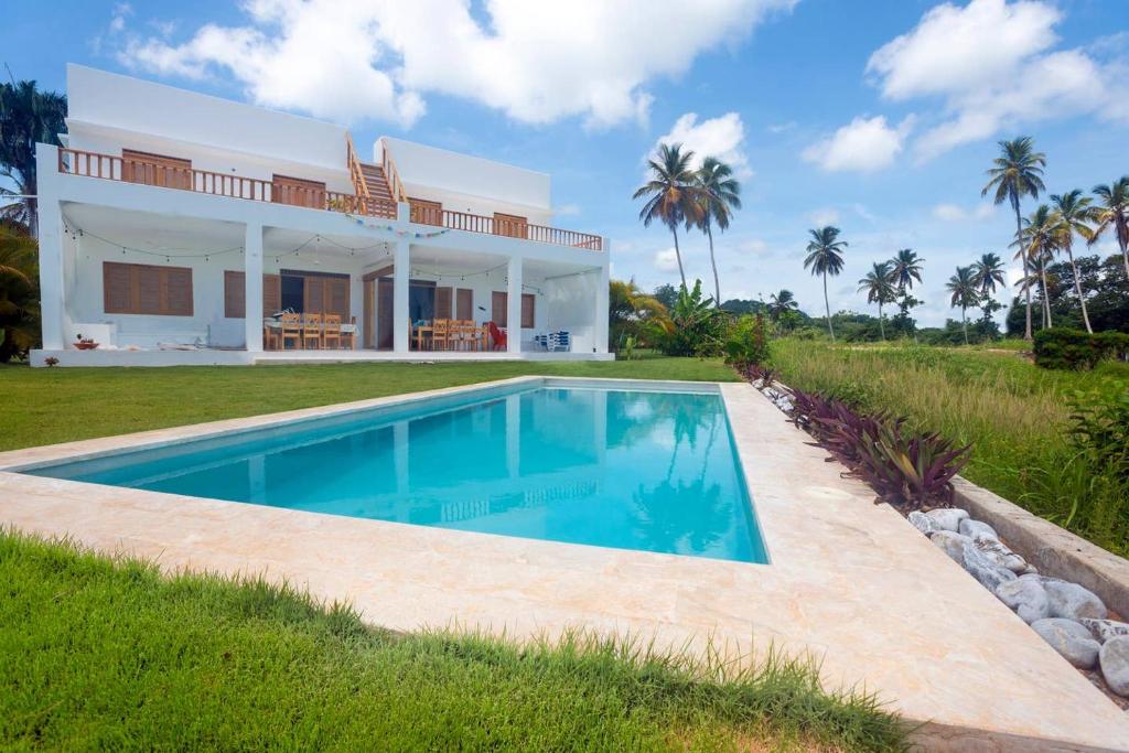 a villa with a swimming pool in front of a house at Villa Kalfu in Las Galeras