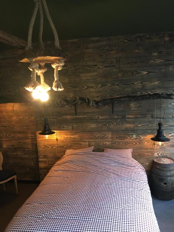 a bed in a room with a wooden wall at Le Santos in Namur
