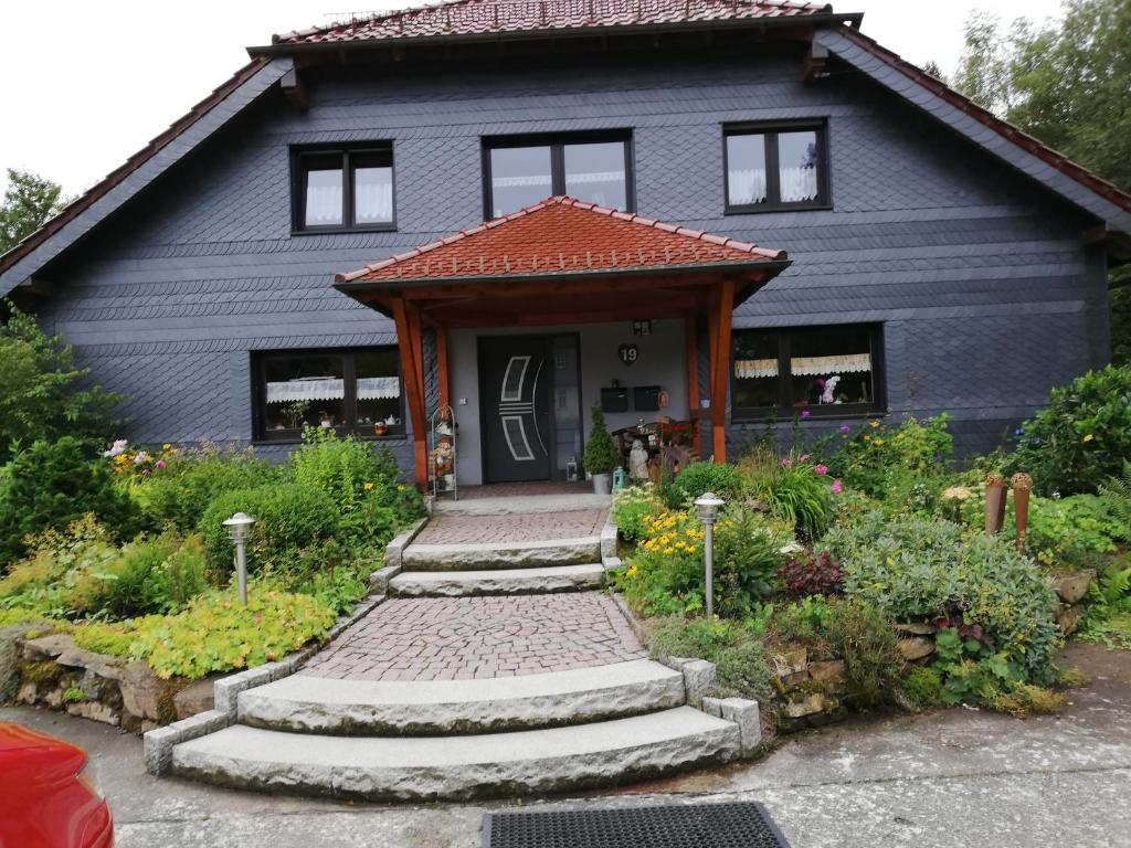 a blue house with a pathway leading to the front door at Ferienwohnung an der Lay Wohnung 2 in Bach