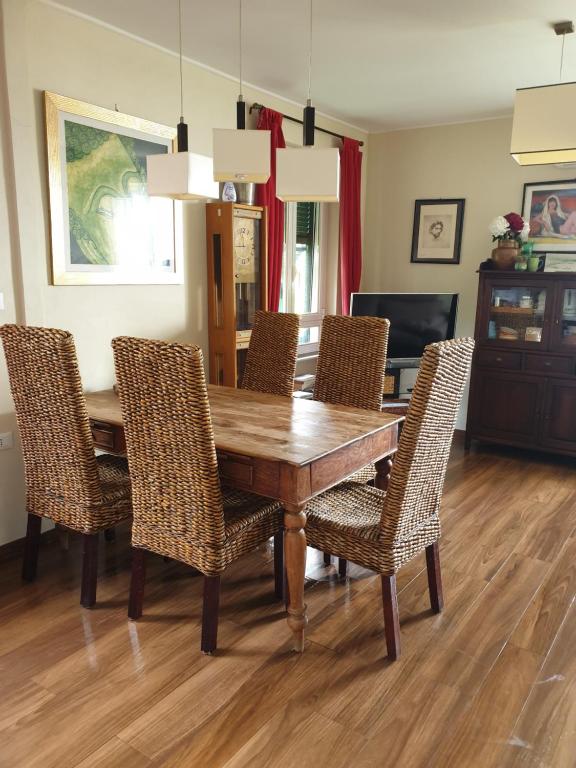 una sala da pranzo con tavolo e sedie in legno di il 23 Holiday Home a La Spezia