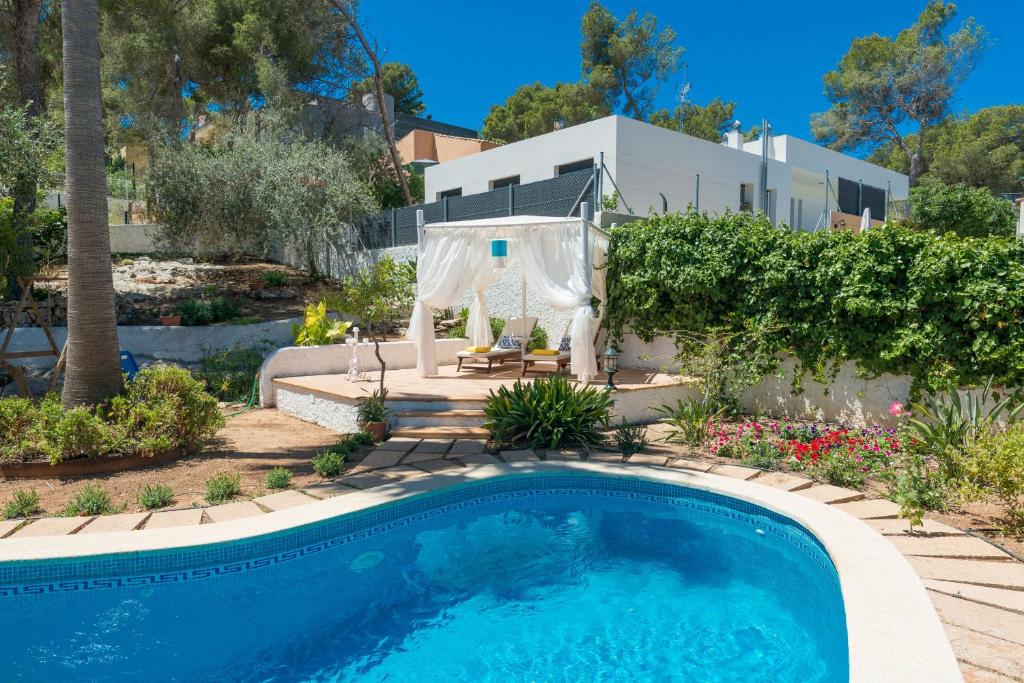una piscina in un cortile con una casa di Villa LOS PINOS a Santa Ponsa