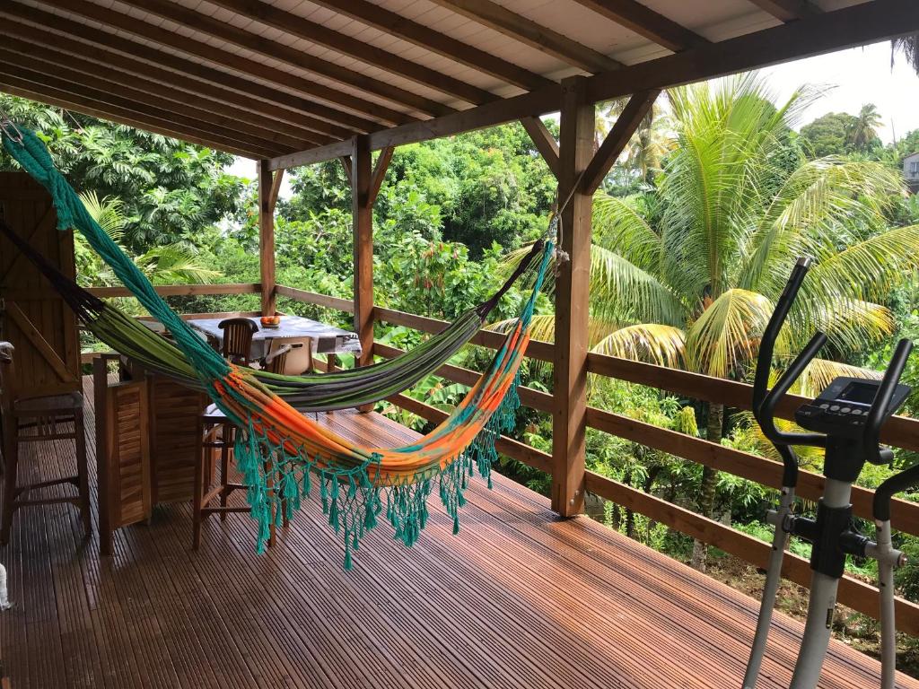 a hammock on the deck of a house at Coconut Studio in Capesterre-Belle-Eau