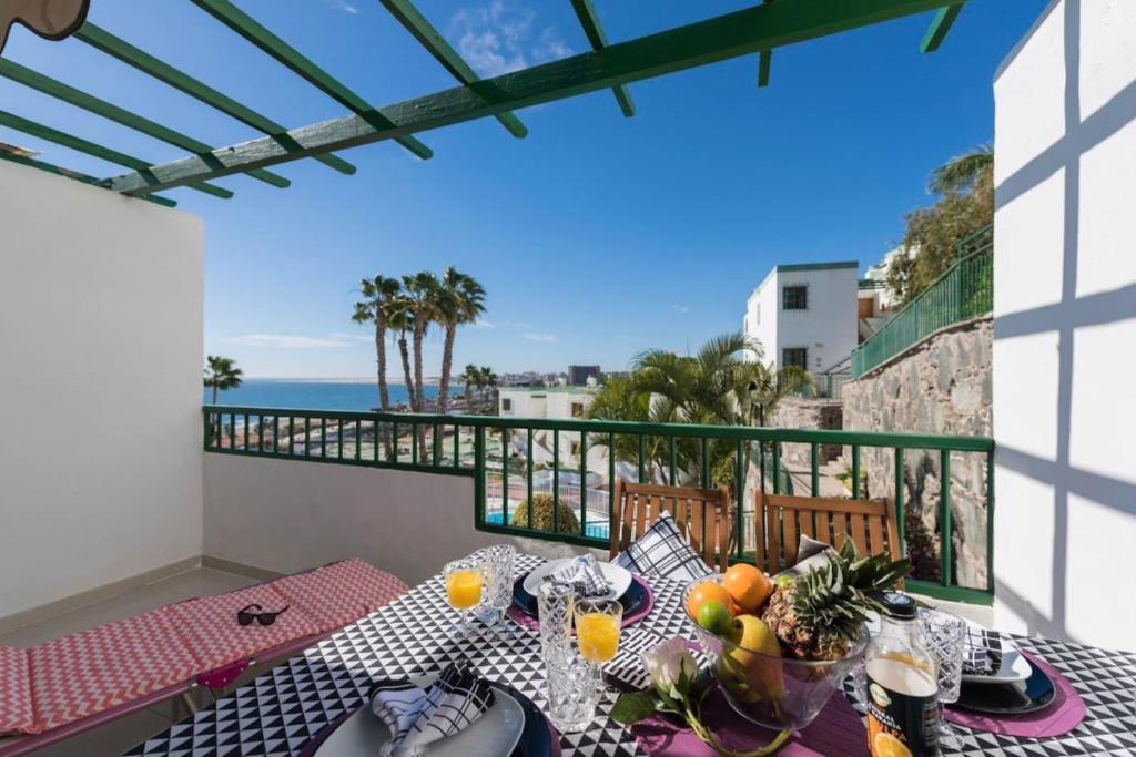 a balcony with a table with a view of the ocean at EXCLUSIVES 2-ROOM APARTMENT TOPLOCTAION 5 minutes to beach San Agustin in San Bartolomé de Tirajana